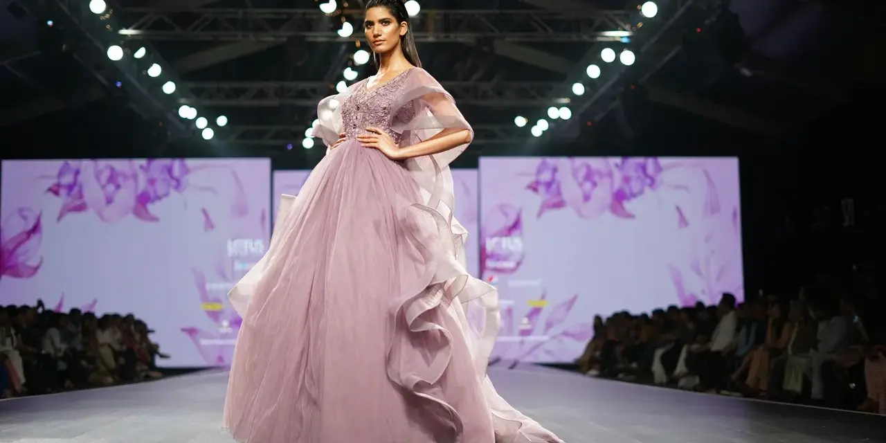 Modelka prezentuje suknię haute couture z muślinu i tiulu na pokazie mody.