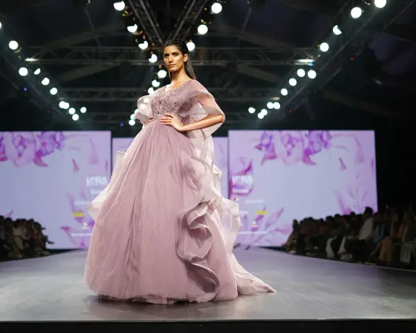 Modelka prezentuje suknię haute couture z muślinu i tiulu na pokazie mody.