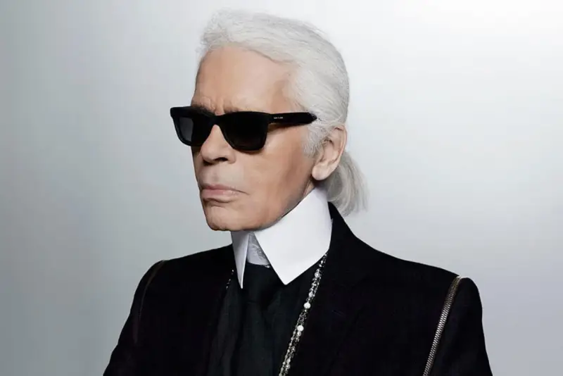 Karl Lagerfeld, jeden z najbardziej znanych projektantów mody, w charakterystycznych okularach i z siwym kucykiem.